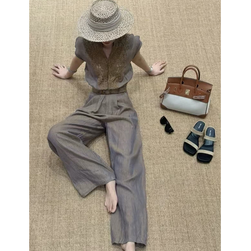A sophisticated and elegant old-money style outfit for a refined and intellectual woman: a gray lace-trimmed jumpsuit.