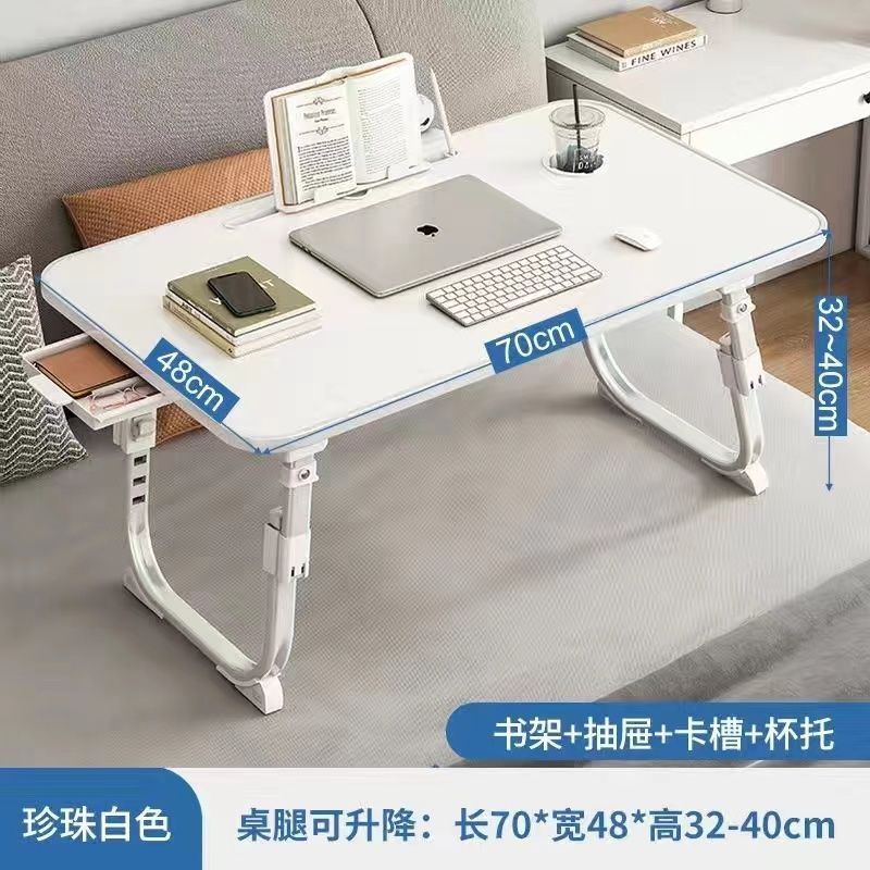 ベッドの上の小さい机のノートパソコンの机の上で折り畳みます。|undefined