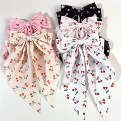 かわいいさくらんぼプリントの蝶結びのスプリングは甘い花のヘアピンを挟んでいます。