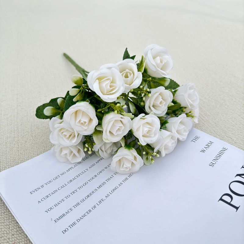 模造花ミニバラは花を手にして家にいる結婚式の室内客間の装飾に造花を飾っている|undefined