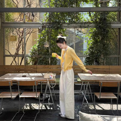 早春の韓国系は黄色のニットカーディガンを着ています。