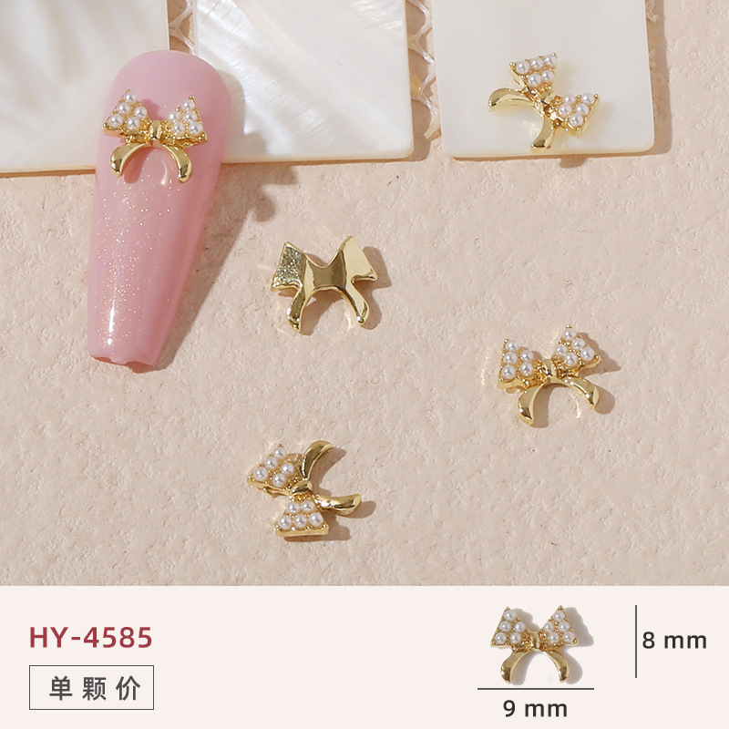 Uñas mariposa joyería nueva línea popular perla arco metal decoración de uñas pequeños accesorios de joyería al por mayor