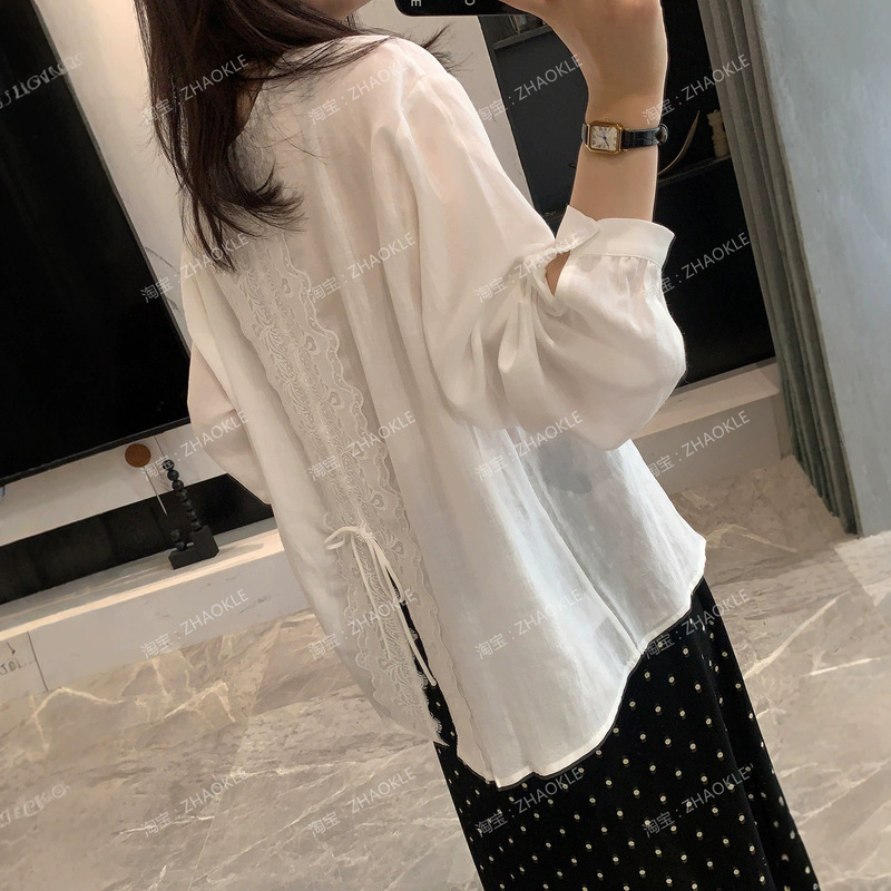 Spring is never too late for this stunning silk and ramie shirt! A loose-fitting white blouse with a round neckline and lace detailing on the back, perfect for creating a stylish and atmospheric look