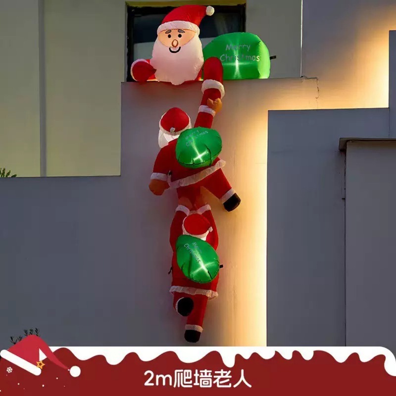 国境を越えて2メートル3人のサンタクロースが壁に登ってクリスマスの屋外の飾りを入れる|undefined