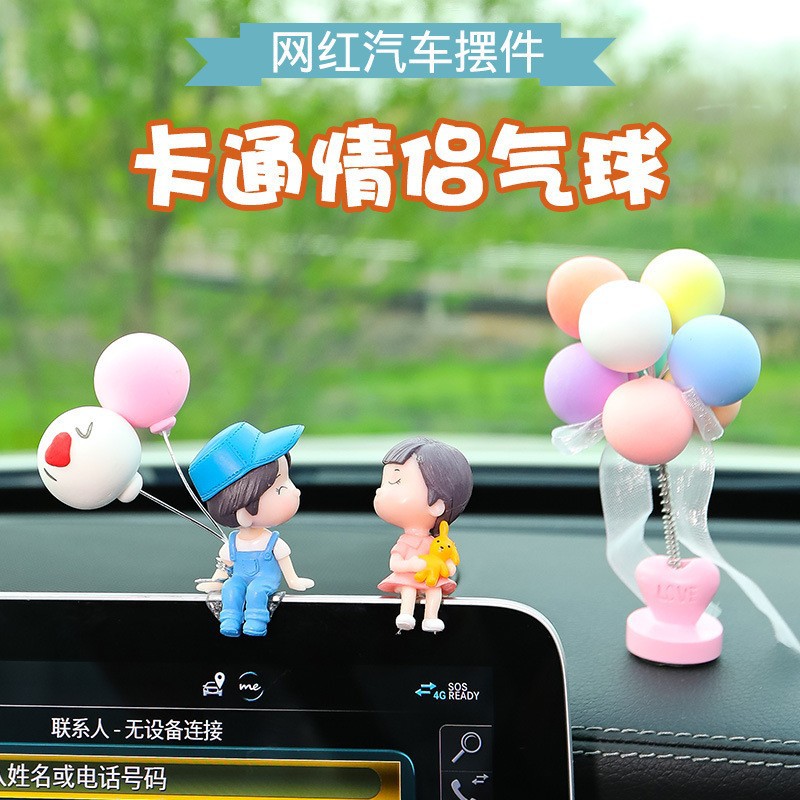 車の可愛いカップルが車内を飾って車を飾って家のオフィスを飾って計器台を飾って飾っています。