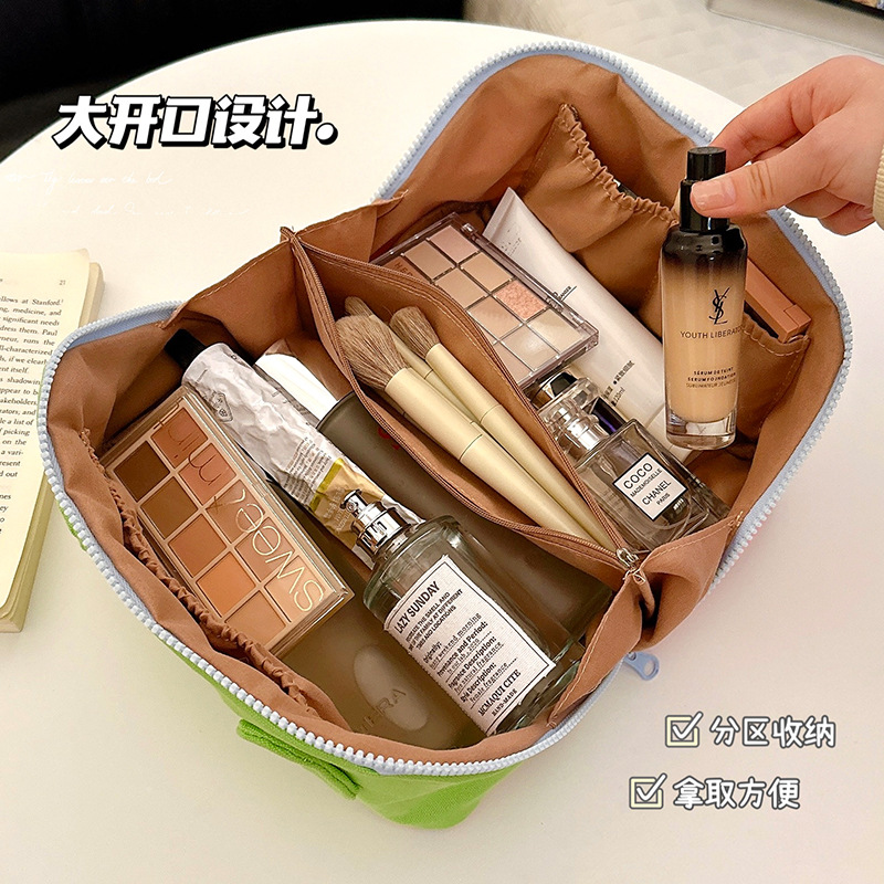 Bolsa de maquillaje de bordado de crema de alto valor visual simple para salir bolsas de lavado portátiles de gran capacidad nicho bolsas de almacenamiento para mujeres