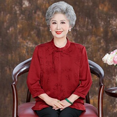 中高年の女性のお母さんの喜姑の披露宴のウェディングドレスのおばあさんの唐服のおばあさんは誕生日の赤いシャツを詰めました。