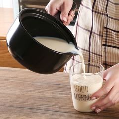 陶磁器の乳鍋の小さい土鍋の赤ちゃんは熱い煮てお粥を煮ます。