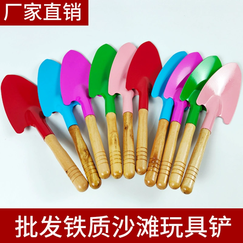 Дети детского сада играют в песок, копать почву, садовые инструменты