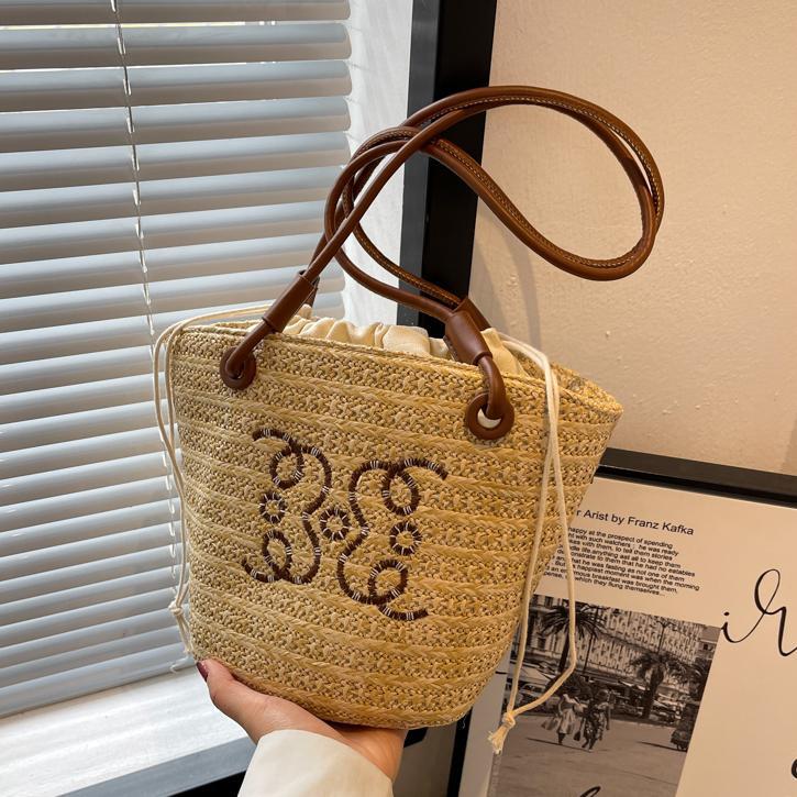 Bolsos tejidos populares de verano para damas 2025 nuevo bolso de cubo de moda de nicho de venta caliente bolso de hombro de estilo occidental de todo fósforo