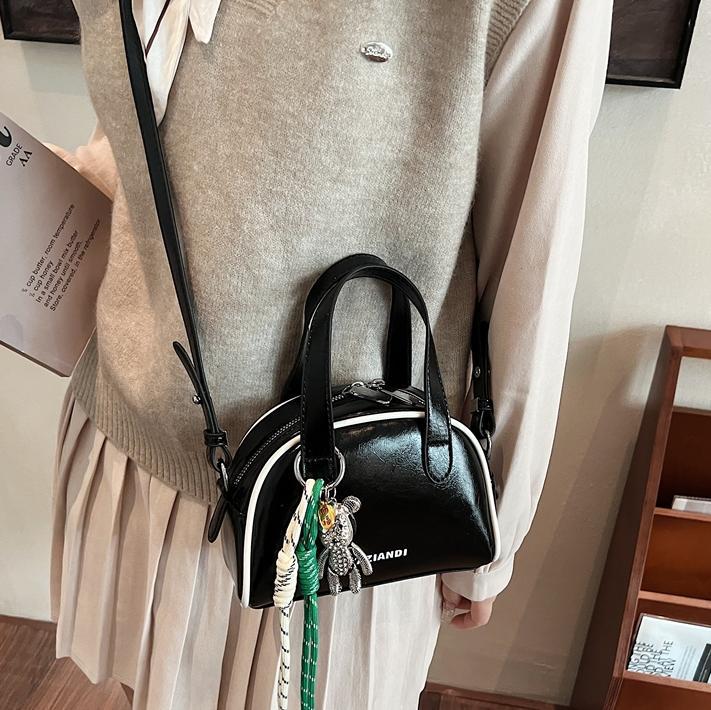 Bolsa de bolos para mujeres 2025 nuevo bolso de hombro de mano de color universal nicho simple de moda alta sensación de mochila