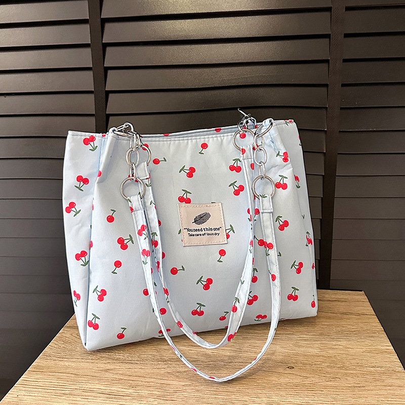 Moda pequeña y fresca impresión de cereza bolsos de invierno 2025, bolsos de mujer nuevos, bolsos de gran capacidad, bolsos de mujer de estilo exterior.