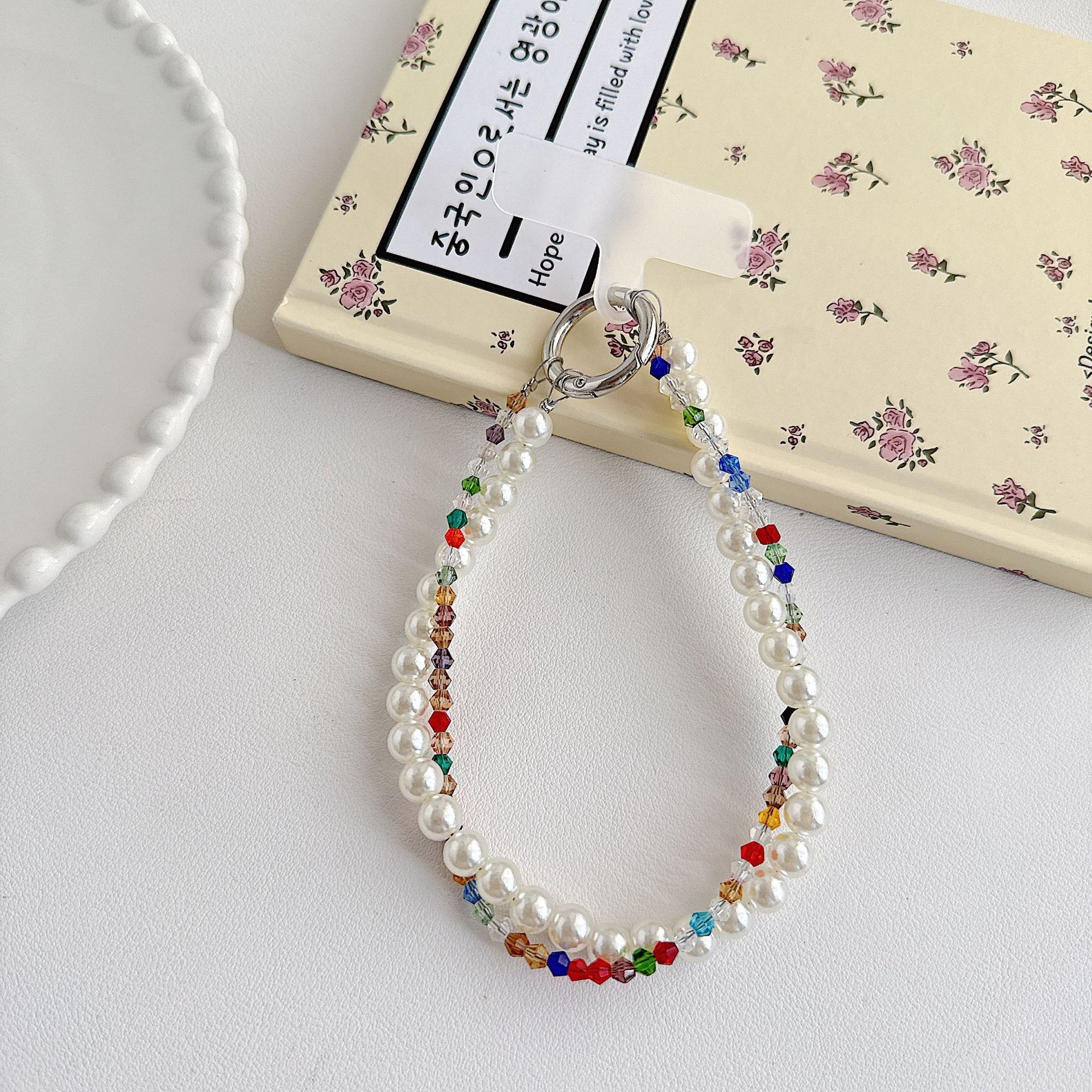 Boutique hecho a mano de alta gama teléfono móvil cadena colgante mujer estilo ins cristal coreano perla enrollamiento cadena de muñeca moda corta