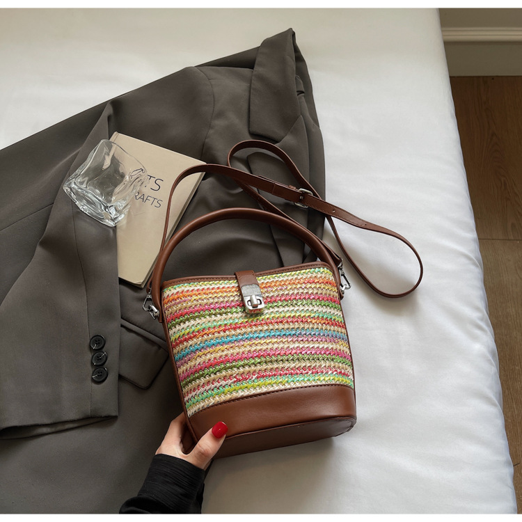 Bolso tejido femenino 2025 nuevo bolso de mensajero de diseño de nicho bolso de cubo de estilo occidental portátil a rayas de color de contraste popular