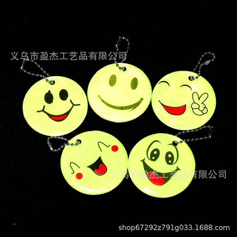 Muchos colgantes reflectantes transfronterizos sonrientes para niños viajan por la noche PVC seguro al aire libre