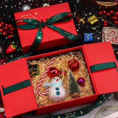 現物の赤いクリスマスのおせちのギフトボックスは、ドアを開けて蝶結びのギフトボックスを持っています。