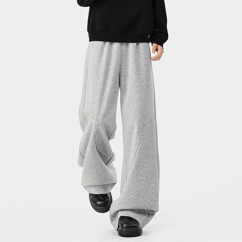 Gray split wide-leg sweatpants for men, high-waisted with diagonal stitching, loose and drapey, floor-length casual pants with a relaxed street style feel
