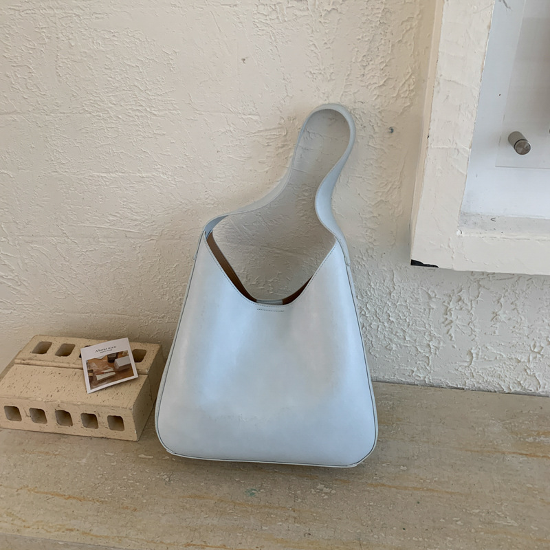 Nicho de diseño simple bolso de cubo portátil para mujeres 2026 primavera nueva moda perezosa retro bolso de brazo diario