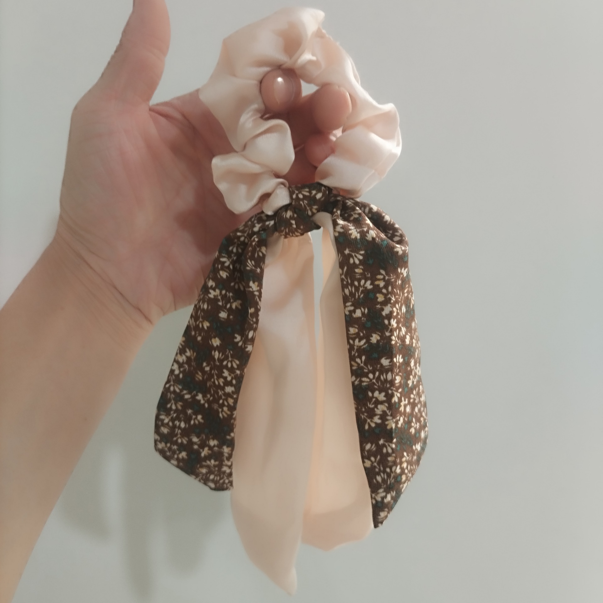 リボン付きの蝶結びの髪紐が低いポニーテールの髪飾りの高級感があります。
