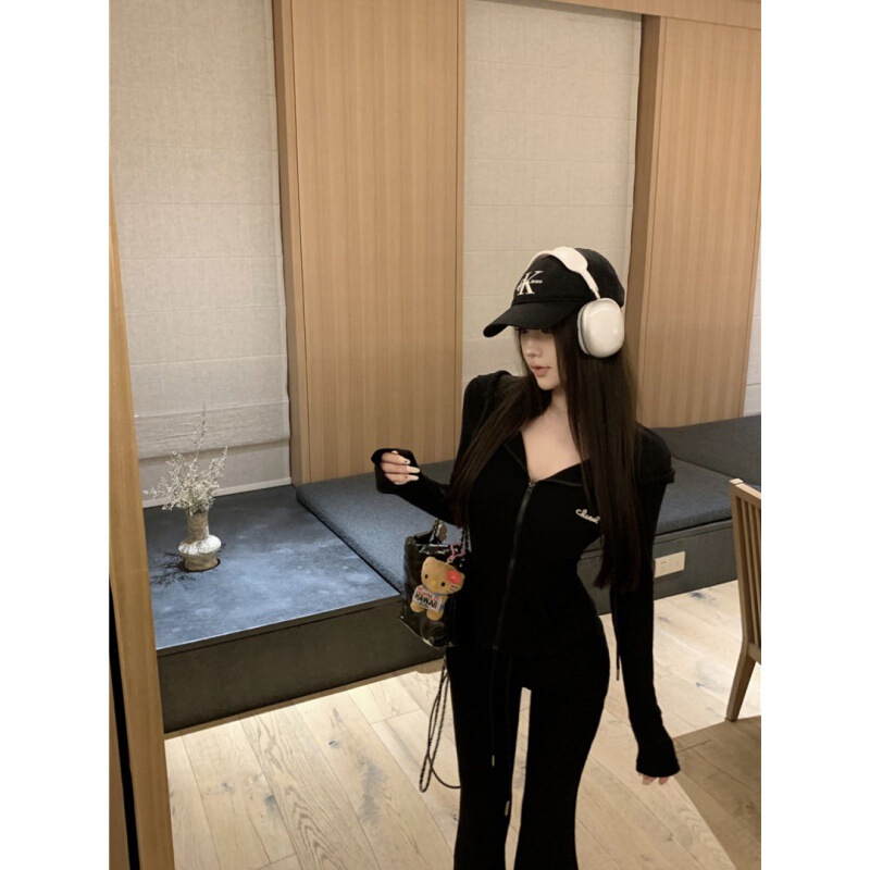 カジュアルスポーツスーツの女性は秋に帽子をかぶって腰のガードルのコートを着て、スピーカーでズボンを2セット持っています|undefined