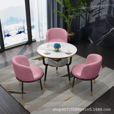 핑크색 가죽 의자 3개와 테이블 1개