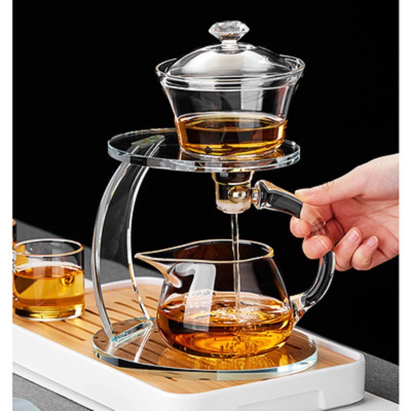 Fábrica al por mayor de vidrio resistente al calor taza de té perezoso traje hogar Kung Fu juego de té engrosada tetera de succión magnética Fabricación de té automática