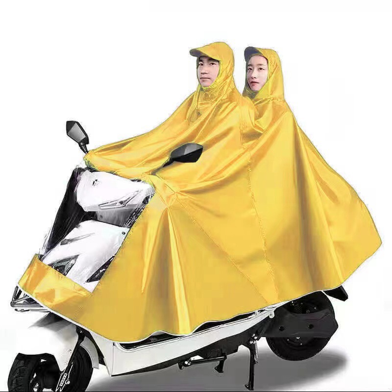 レインコート電気自動車のレインコートを大きくして、オートバイの二人のシングル男性女性が豪雨防止全身に足を隠します。|undefined