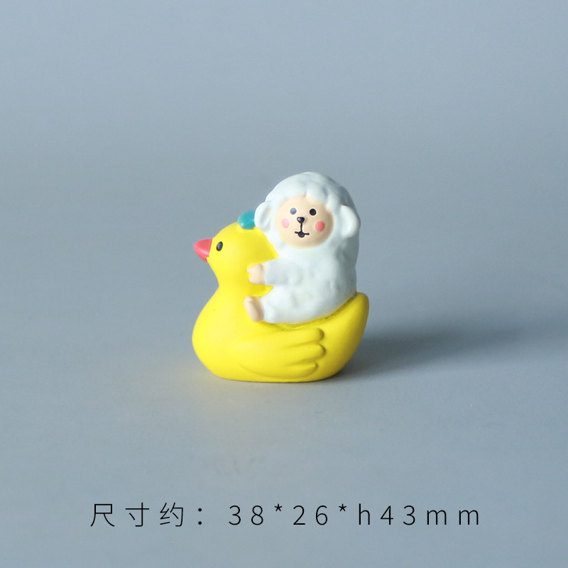 작은 노란 오리 양을 타고