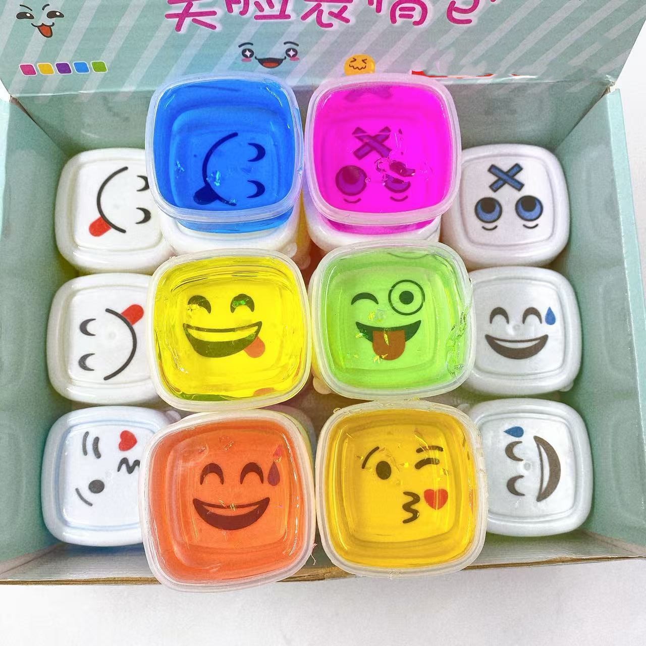 Nuevo paquete de emoticonos de cara sonriente de 24 entrada, pegamento espumoso, lodo de color slime, pegamento M, arcilla de cristal, juguetes para niños de bricolaje al por mayor