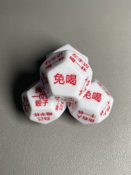 12-sided engraved dice with red characters on a white background, a fun drinking game prop for bars