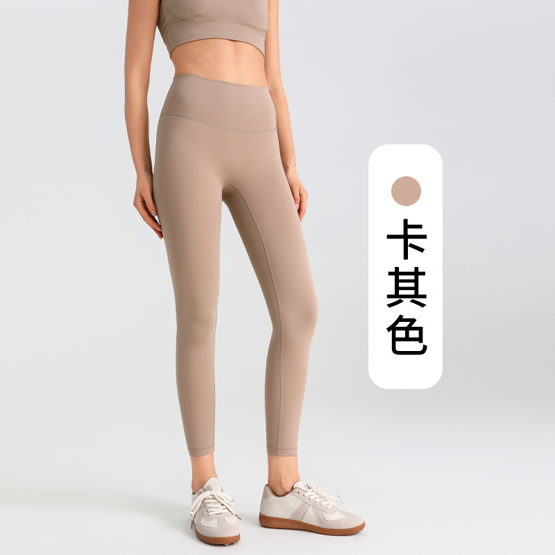 ヨガのズボンの女性は腹を収めて尻を持ちます。|undefined