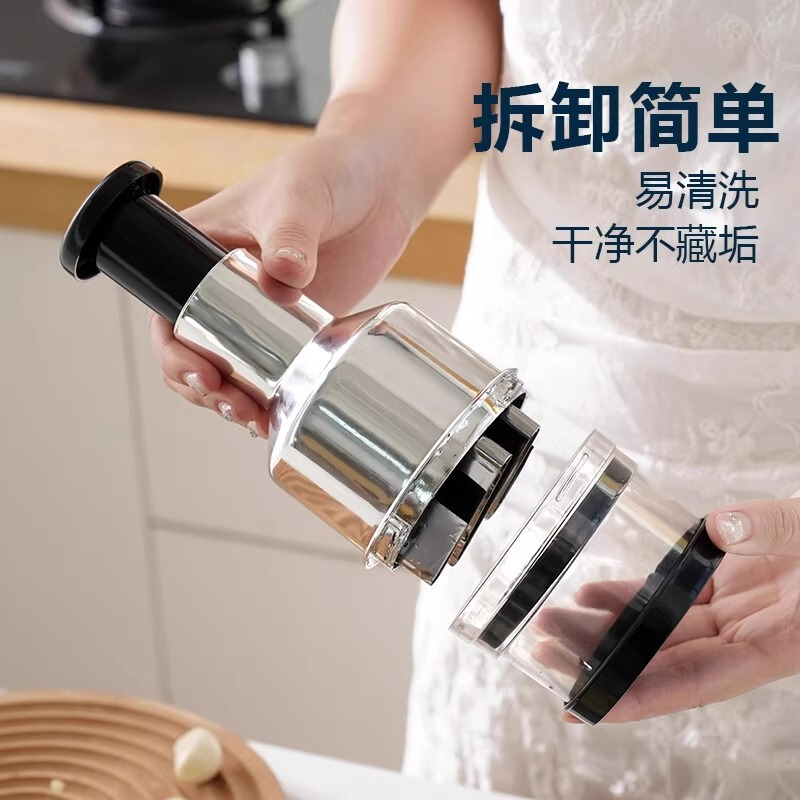 ナイフをたたいてステンレスの手押し式の野菜切り器の台所は手動でニンニクの泥をいじります。|undefined