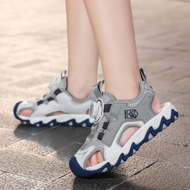 Sandalias Baotou para niñas 2025 nuevo botón giratorio para niños grandes zapatos de playa para niños antideslizantes de suela suave y resistentes al desgaste