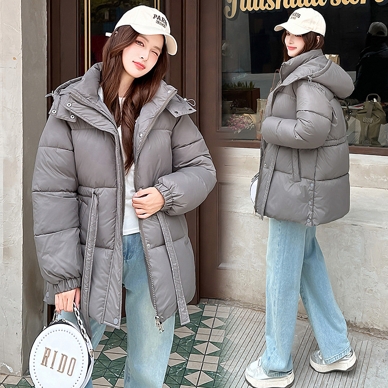 Capa de algodón de pluma de invierno para mujeres, ropa de algodón de cintura gruesa, ropa de invierno 2025, nueva moda de chaqueta caliente con capuzas medianas y largas