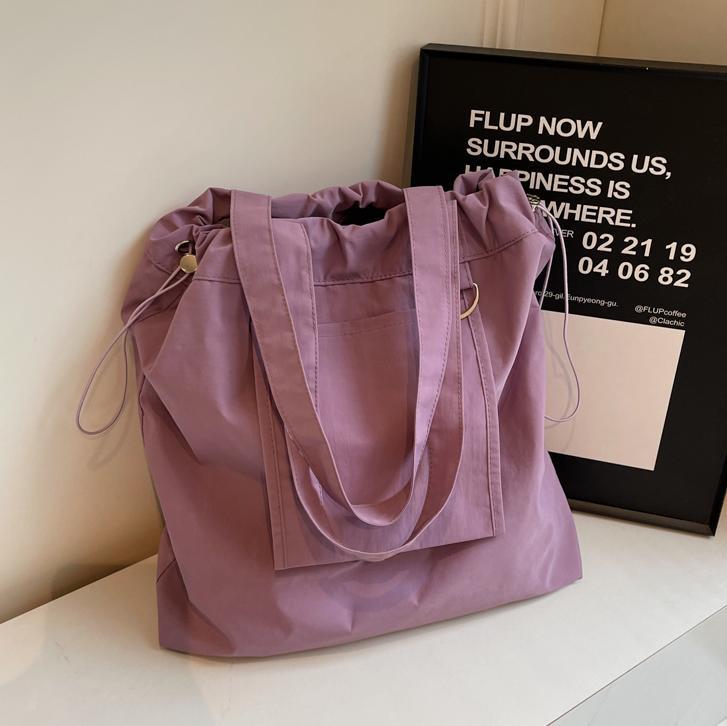 Bolsa de tela de nylon impermeable para mujeres 2025 nuevo tipo bolso de cubo de viaje ligero de gran capacidad bolso de hombro portátil para estudiantes universitarios