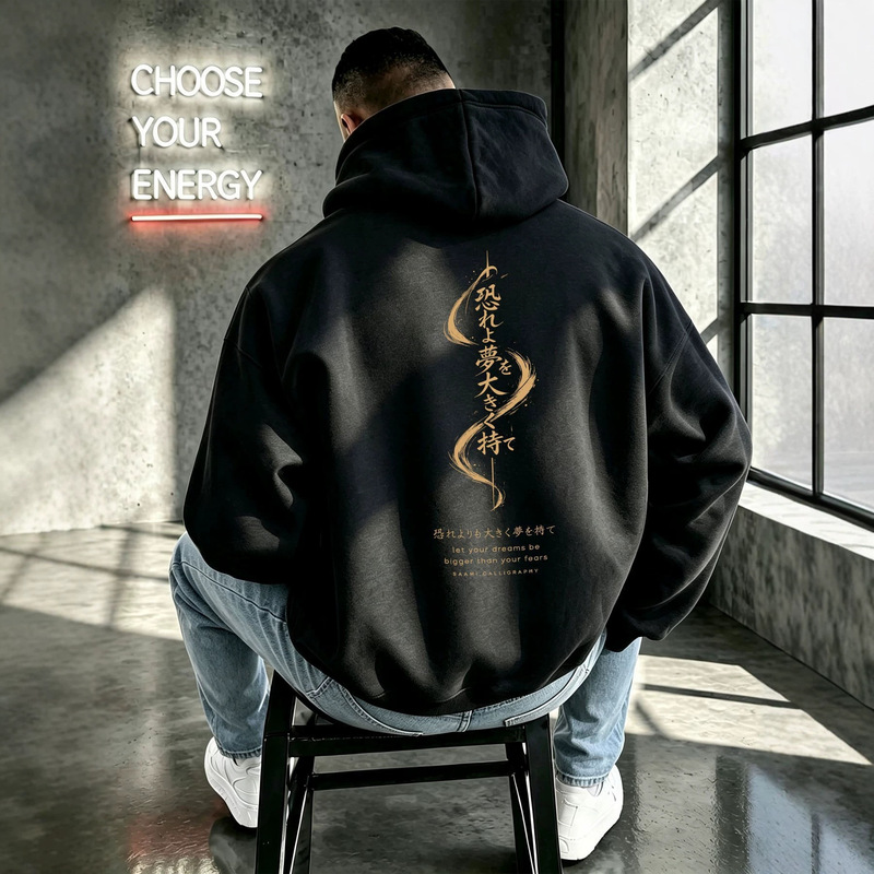 American-style loose-fit, casual, fleece-lined hooded sweatshirt with the slogan "Dreams Greater Than Fear," featuring large gold lettering and gold ink, a new design from a trendy brand American-style loose-fit, casual, fleece-lined hooded sweatshirt with the slogan "Dreams Greater Than Fear," featuring large gold lettering and gold ink, a new design from a trendy brand