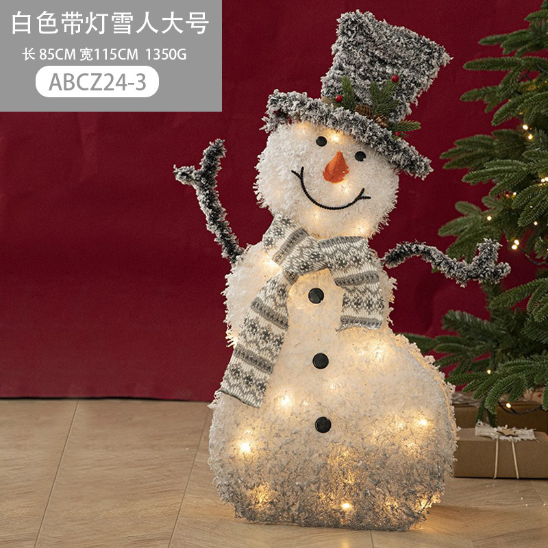 Decoraciones navideñas de muñecos de nieve, adornos de escaparate con una escena de renos de peluche blancos brillantes para la Nochebuena.