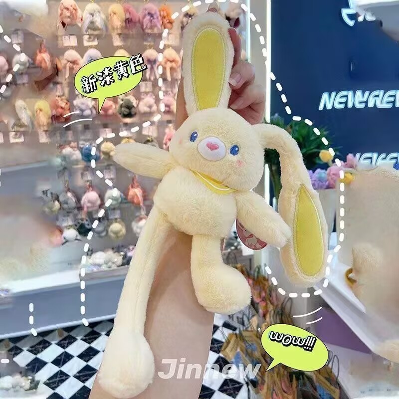 ネットの赤い耳のウサギはウサギの鍵を引いてぬいぐるみのかばんのペンダントを掛けて女の子にプレゼントします。|undefined