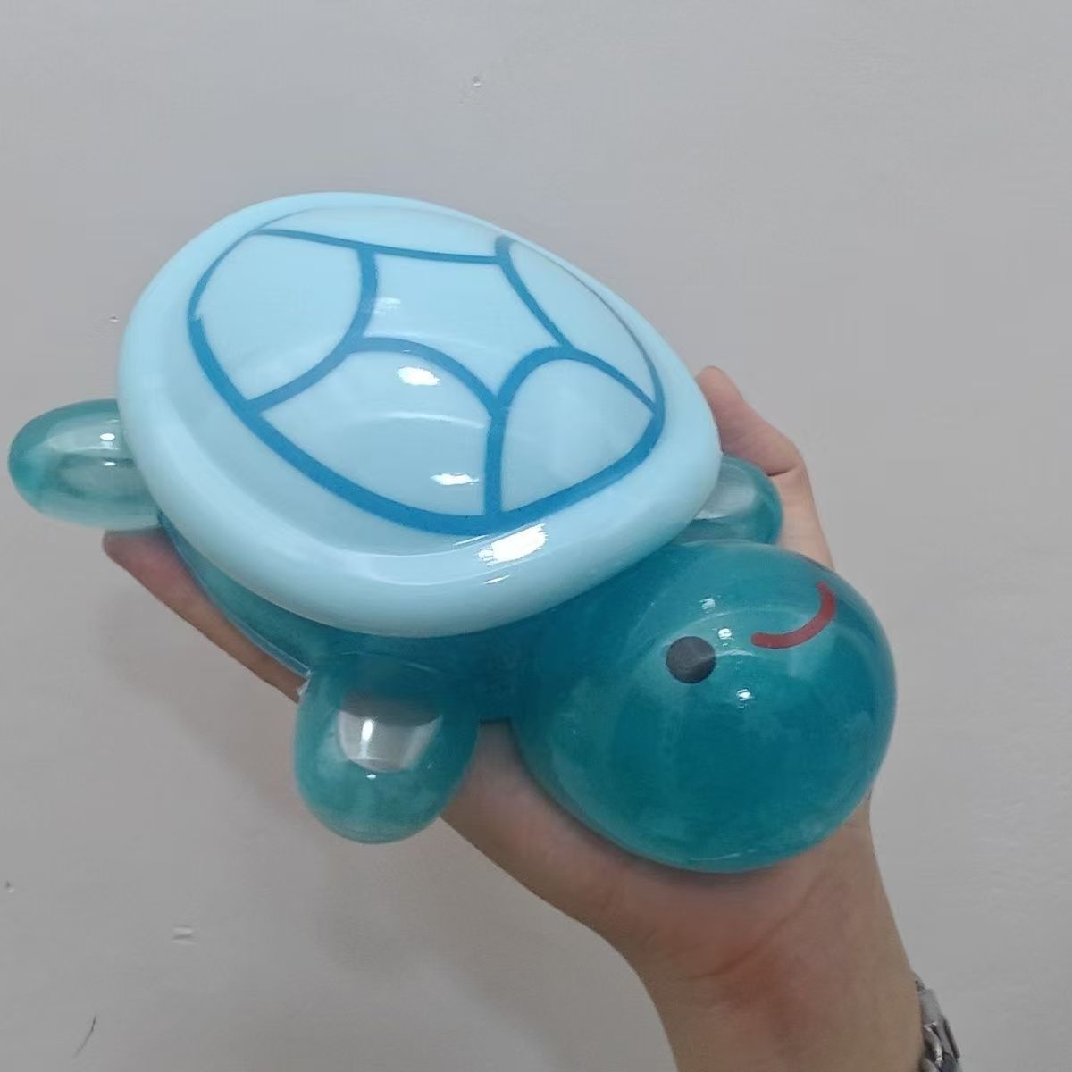 La gran tortuga luminosa se coloca en la caja de almacenamiento Big Mac. La decoración del abuelo de la tortuga luminosa toca los juguetes de decoración del escritorio creativo