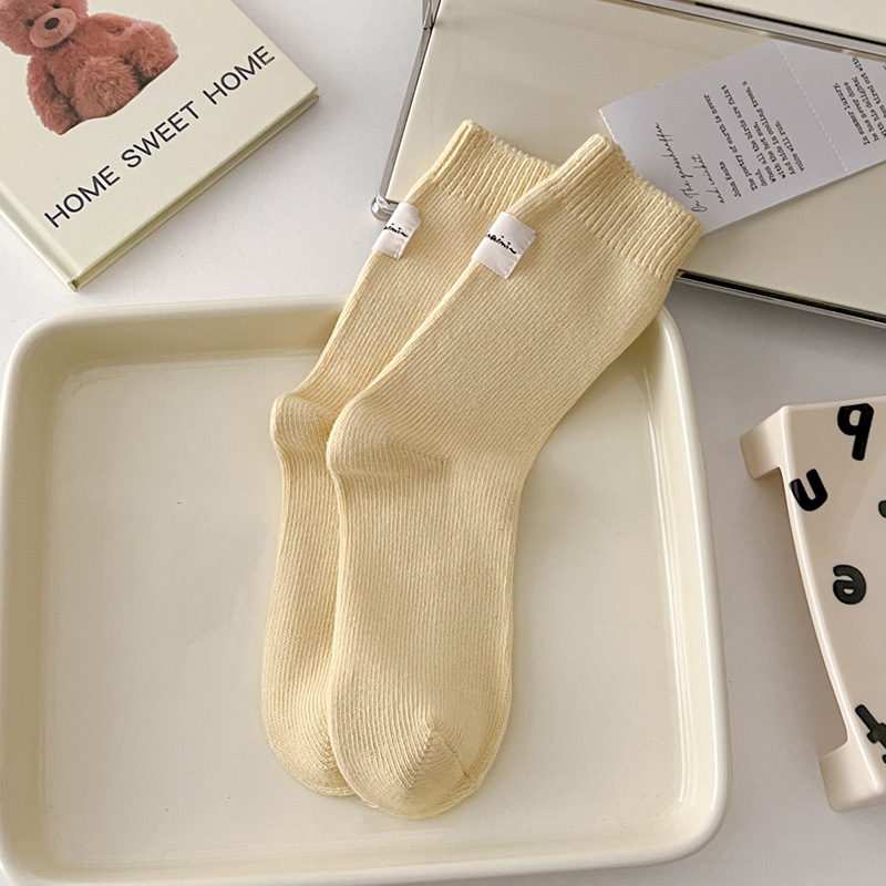 Otoño e invierno Nuevos calcetines de algodón absorbentes de sudor calcetines de pila serie de crema para mujer estilo ins Corea del Sur etiqueta de tela calcetines de media pantorrilla moda
