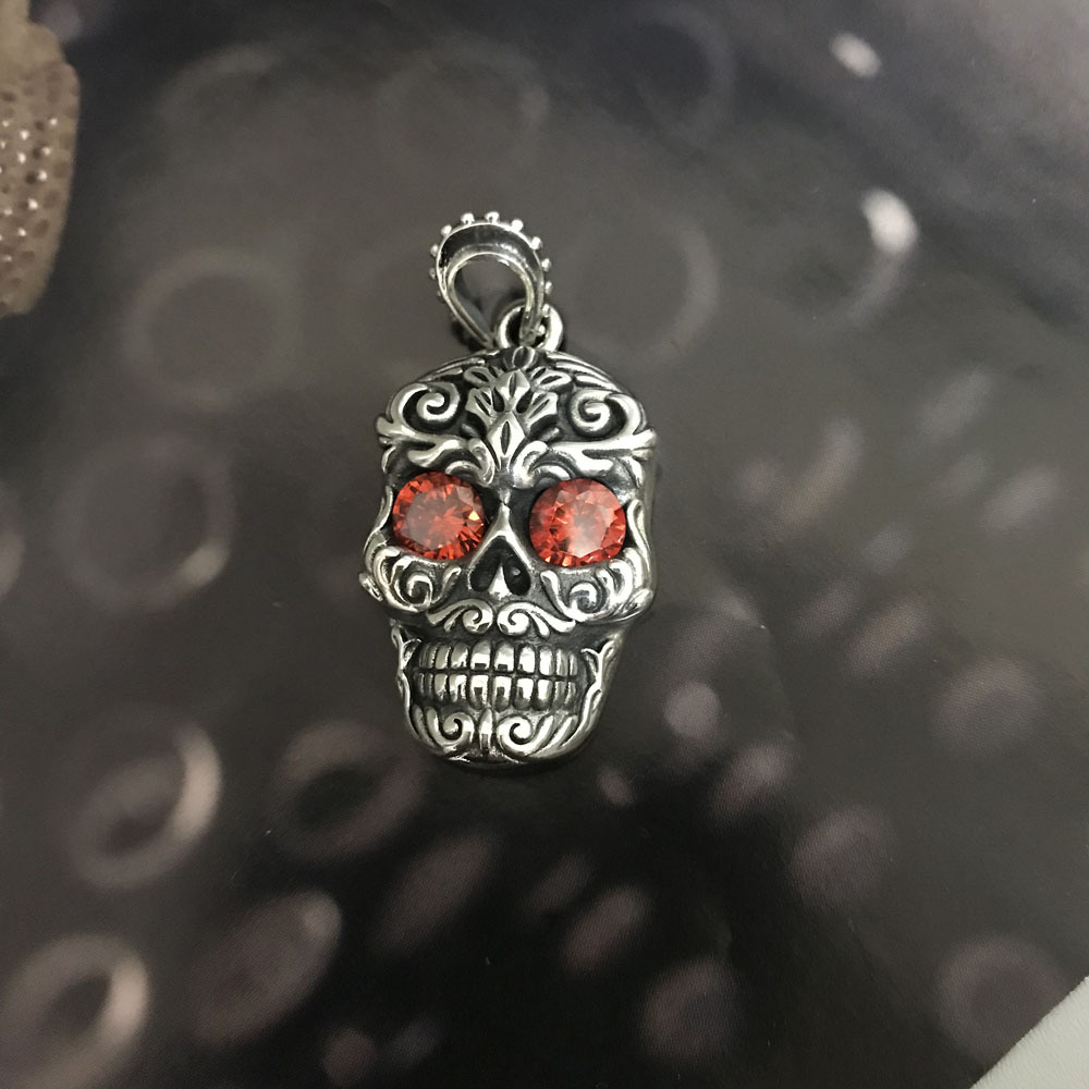 Front view of the massive sterling silver skull pendant with red gemstone eyes
