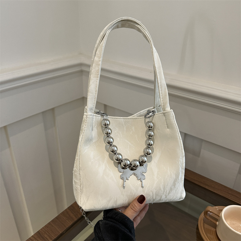 Alta sensación de lujo ligero bolso de cubo axilar 2024 verano nuevo estilo de moda arco de cuentas cadena de hombro mochila