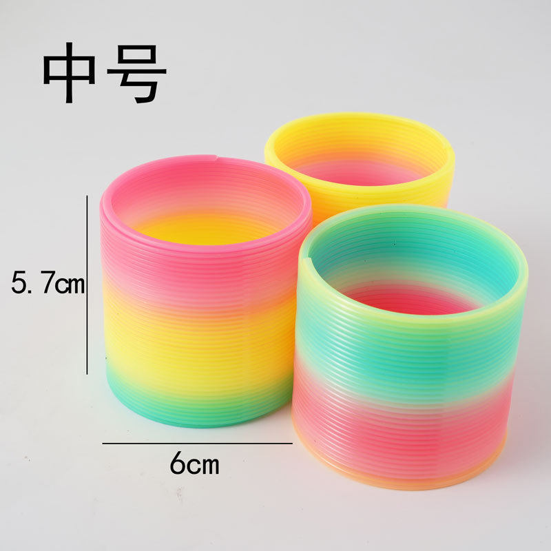 Descomprimir pequeño arco iris anillo laminado juguetes de plástico para niños arco iris anillo de resorte resorte alrededor de la escuela pequeña empresa