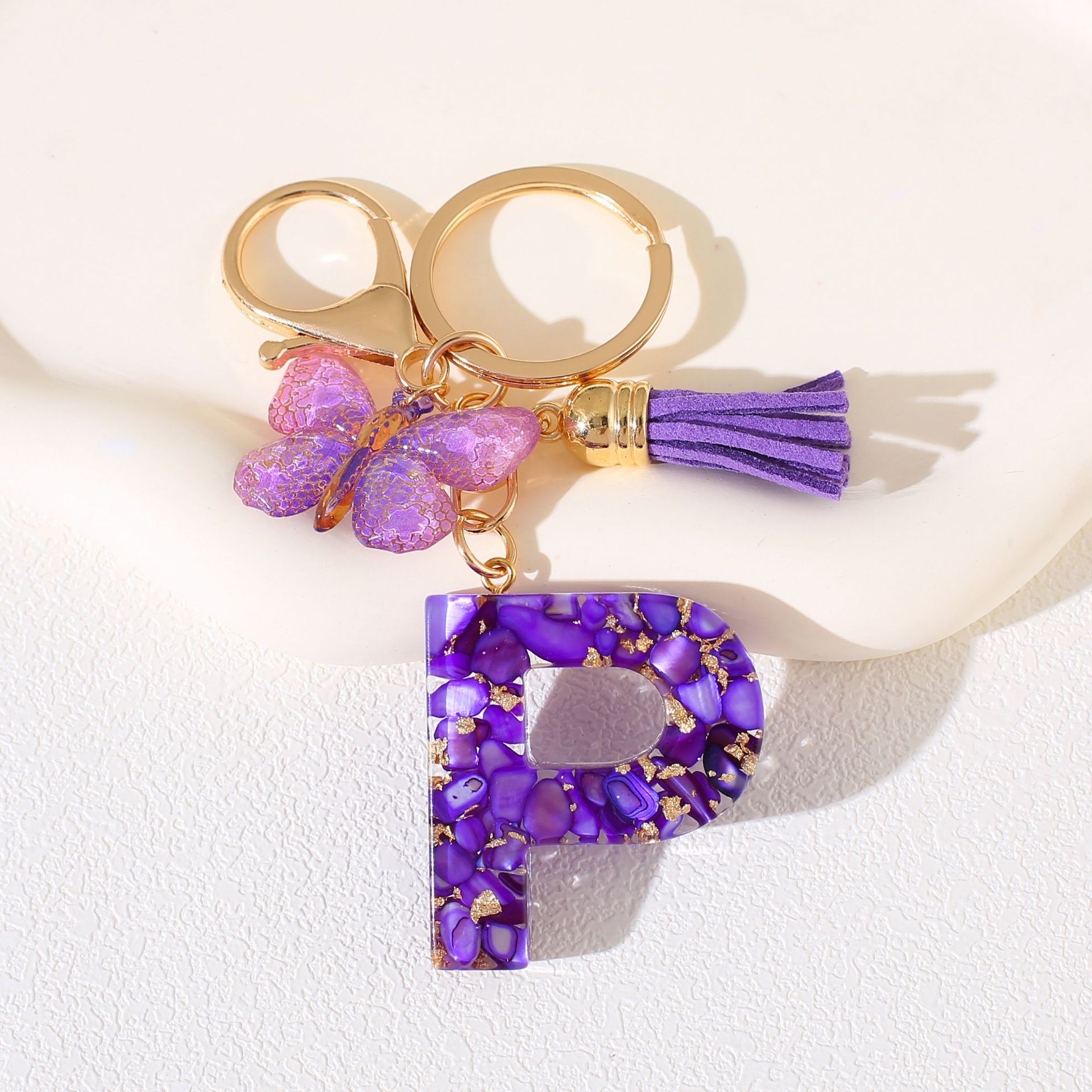 Fábrica directa de Yiwu accesorios de resina de goteo de embalaje llavero anillo de metal letras mariposa brilla colgante damas