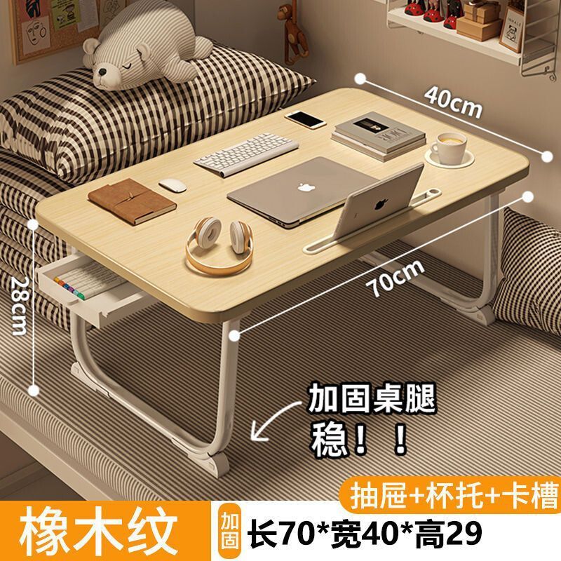 ベッドの上の小さい机のノートパソコンの机の上で折り畳みます。|undefined
