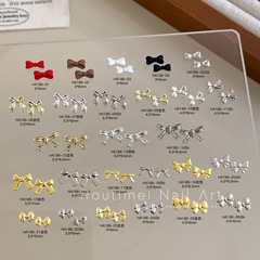 新商品のネイルの蝶結びのシリーズのアクセサリーの砂の合金のデザインは蝶結びの高級感の赤い本を結びます。
