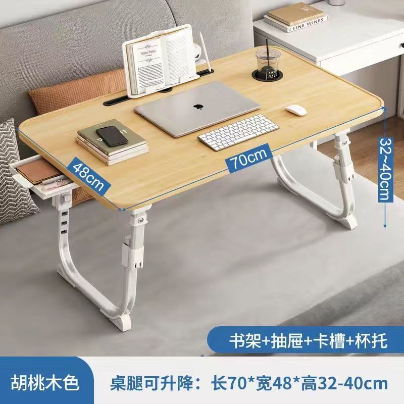 ベッドの上の小さい机のノートパソコンの机の上で折り畳みます。|undefined