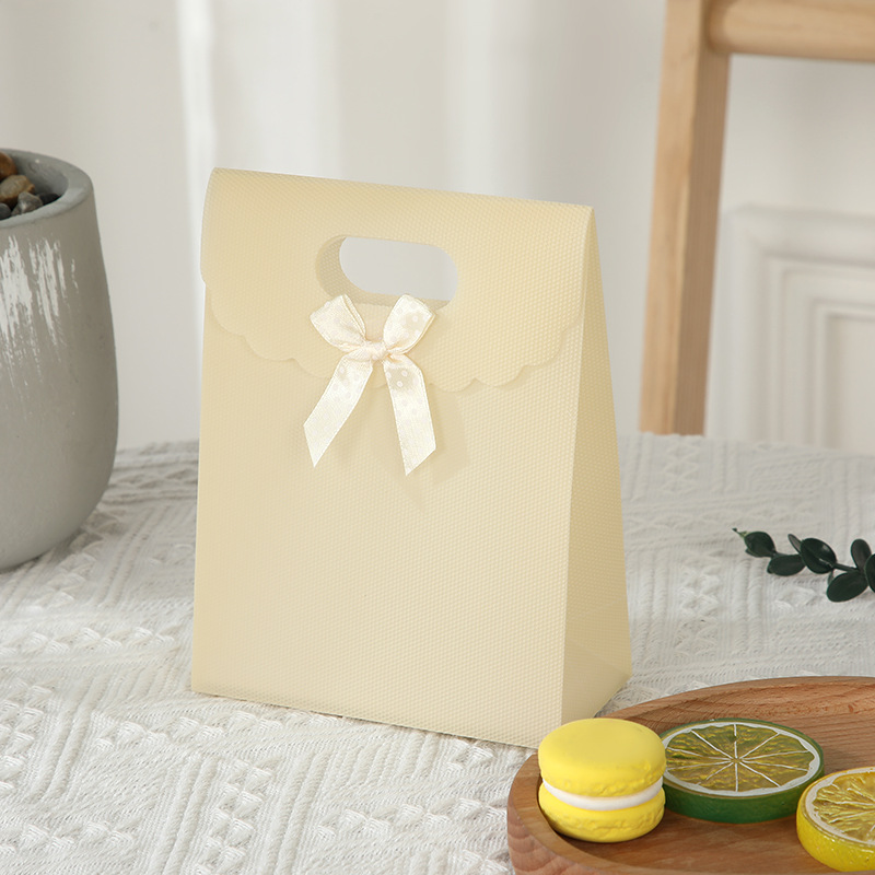 Bolsa de regalo con lazo multicolor, bolsa de mano de polipropileno con tapa abatible, bolsa de regalo con diseño hexagonal tipo ramo.