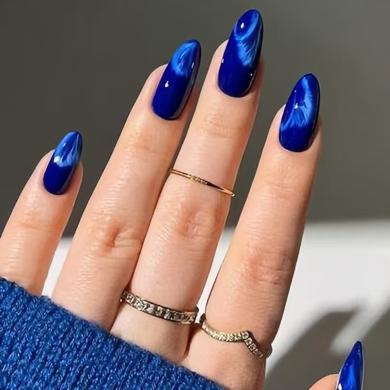 Klein blue long almond-shaped nail tips, featuring a flowing velvet texture and a shimmering, iridescent blue finish, minimalist design Klein blue long almond-shaped nail tips, featuring a flowing velvet texture and a shimmering, iridescent blue finish, minimalist design