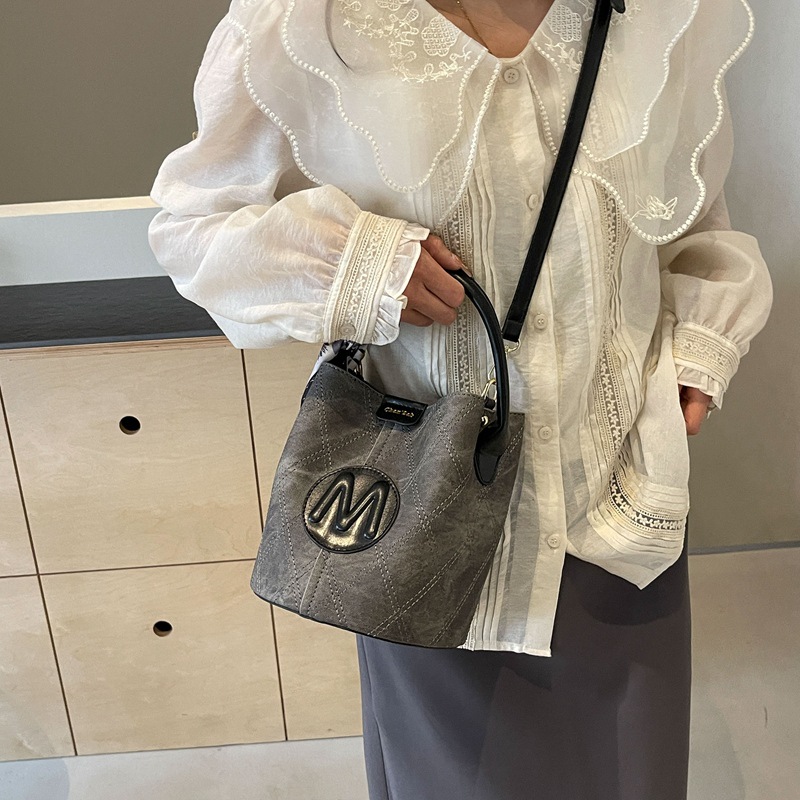 Bolso de mano popular de este año, dama, primavera y verano, 2026 nuevo bolso de cubo de vaquín universal, nicho de textura, mochila